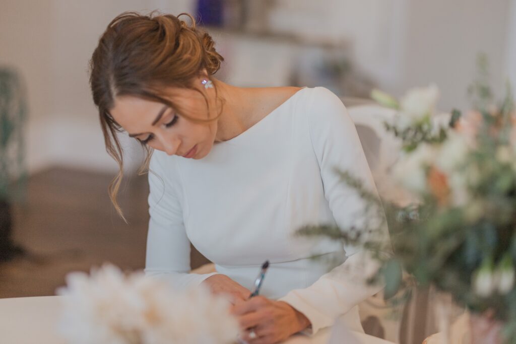 Bride writing a letter to the groom before the wedding ceremony at the White Room, St. Augustine, Florida