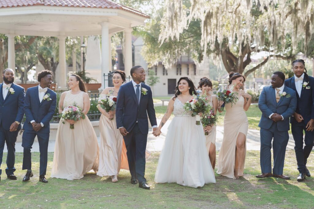 Bride and groom with the wedding party walking in St. Augustine for photos | Phavy Photography