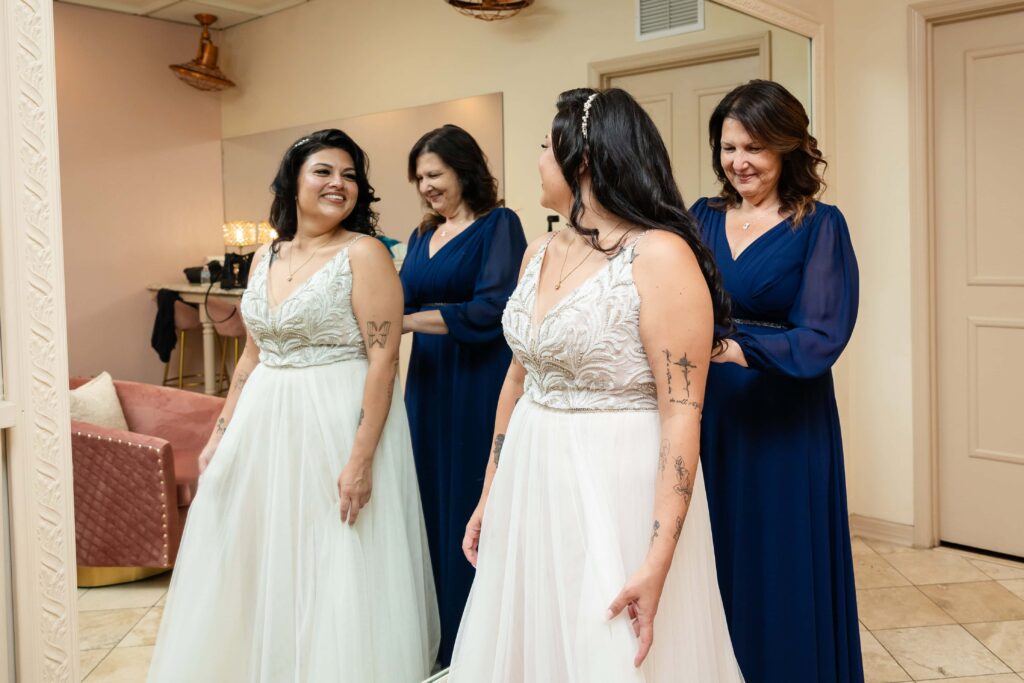 Mom helping daughter with the dress for her wedding day at the Treasury on the Plaza