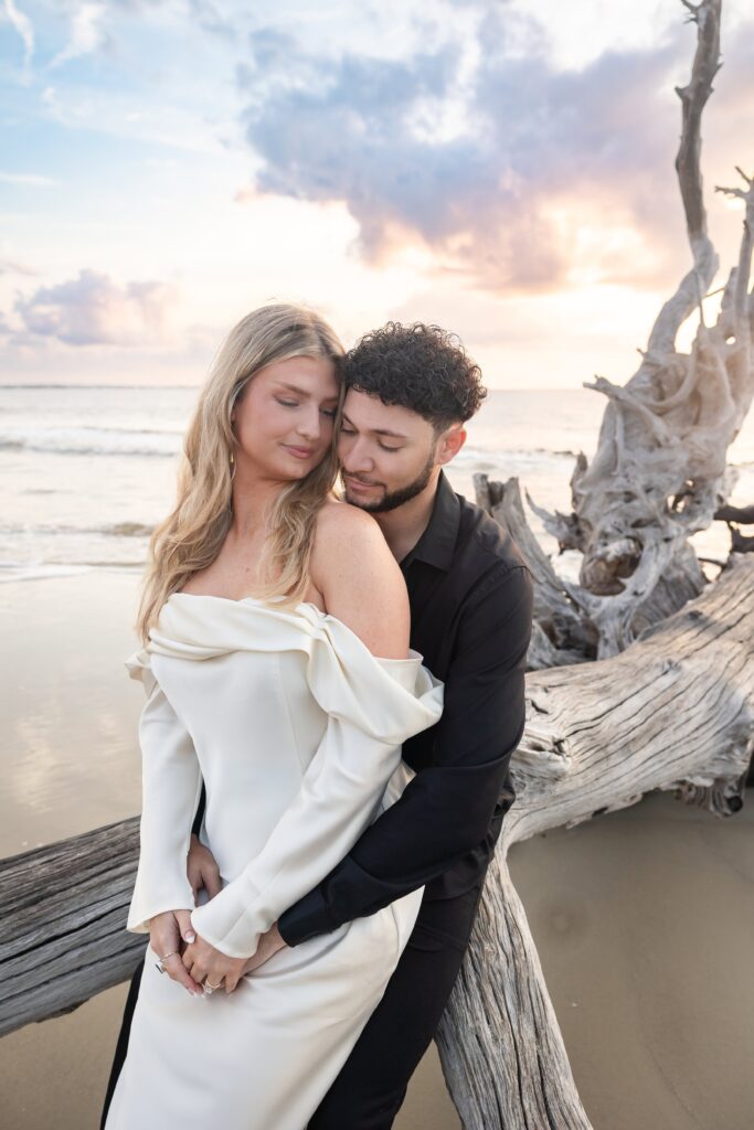 Modern engagement photo with stylish beach backdrop and natural greenery