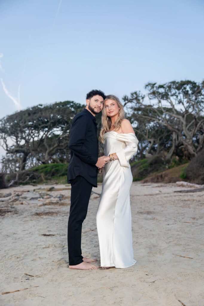 Barefoot couple embracing during a sunrise engagement shoot at the beach