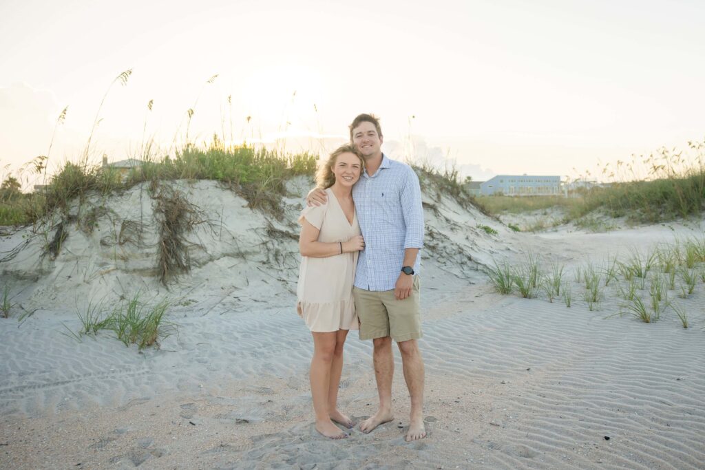 Engaged couple standing on the sand dunes during a St Augustine Beach engagement session