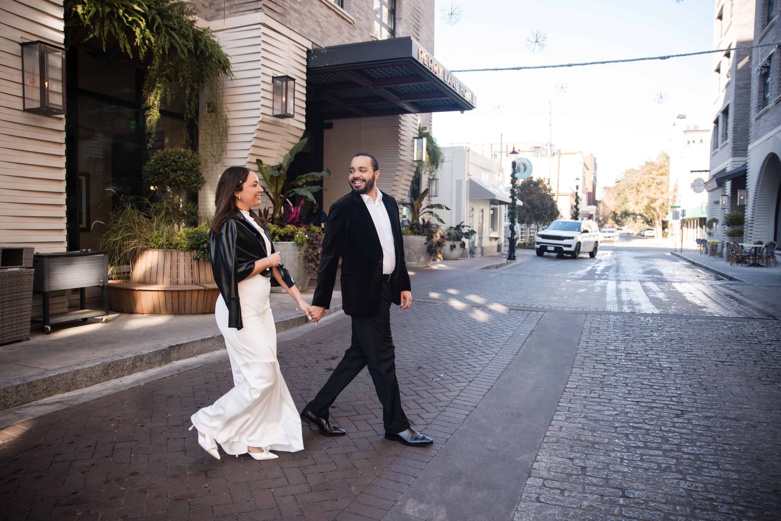 Documentary style engagement photos with bride in white dress and groom in black jacket
