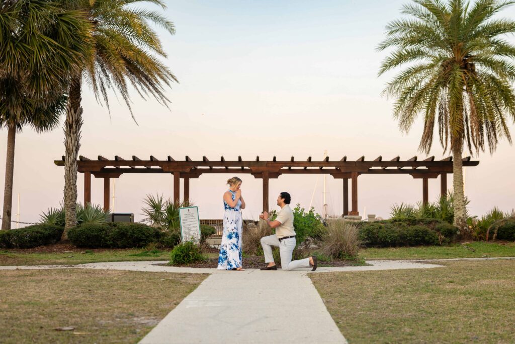 A proposing in St. Augustine at the bay front | Sunset proposal Captured by Phavy Photography, St. Augustine Proposal Photographer