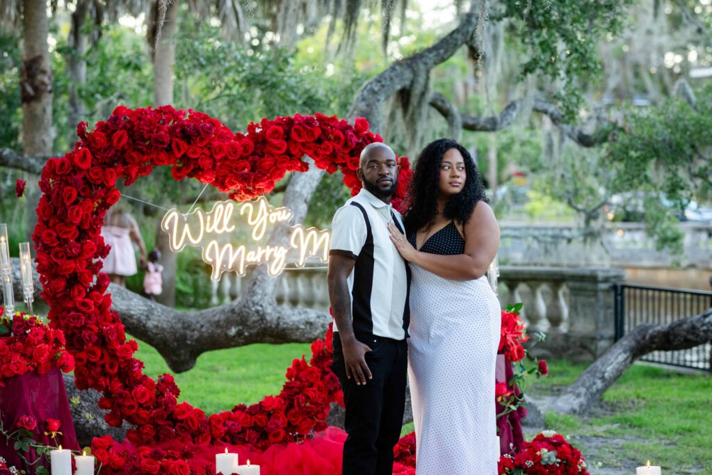 A beautiful black couple in front of a luxury proposal decoration