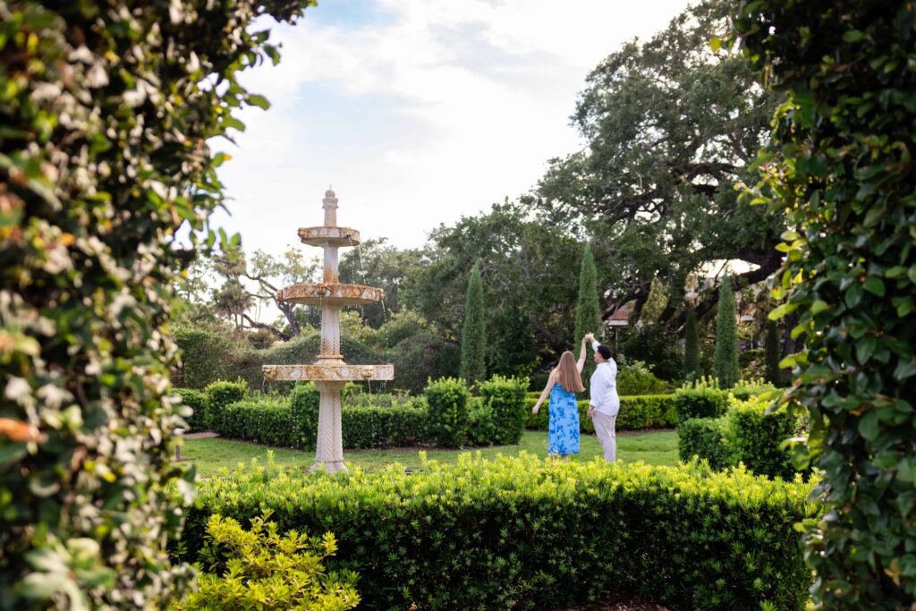 Engagement portraits framed by the Italian Garden's ficus-covered gloriette at Cummer Museum