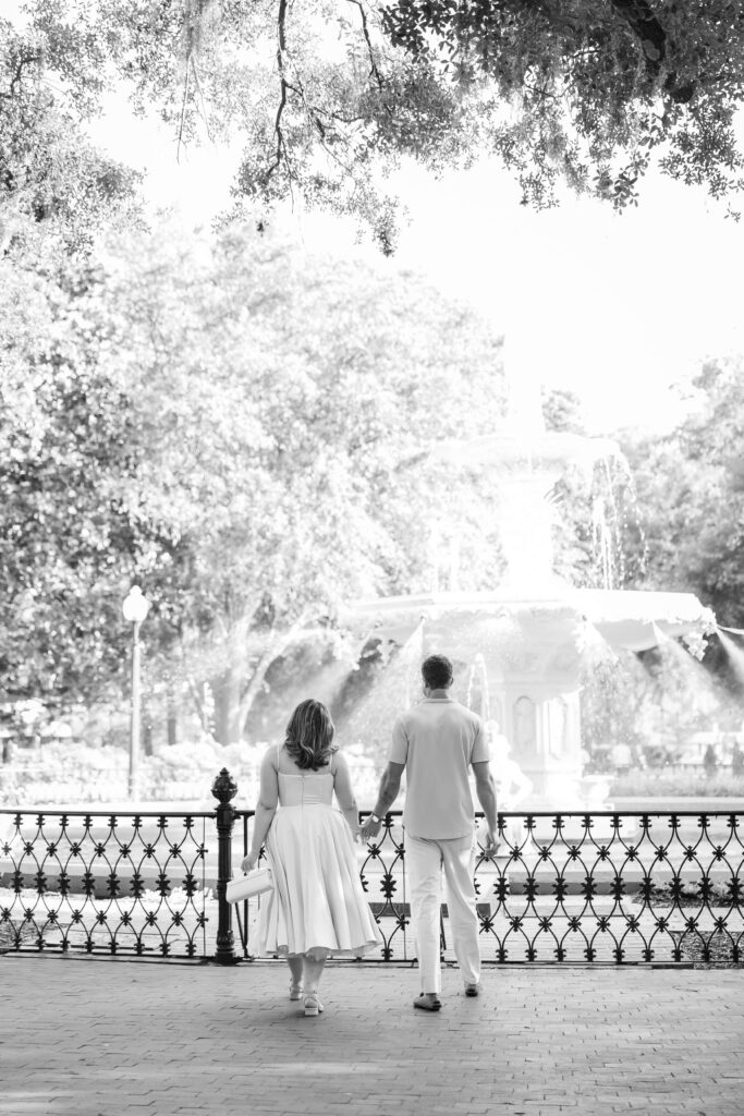 Couple walking to the fountain at Forsyth Park right before a surprise proposal