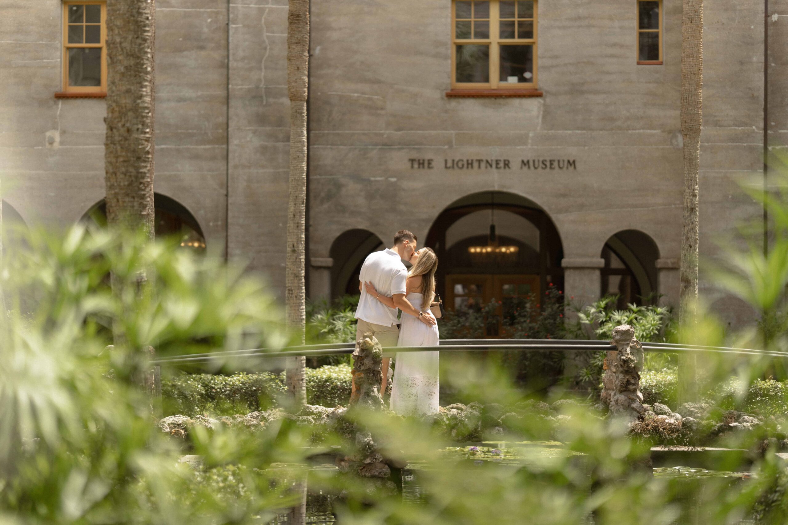Couple embracing after surprise proposal at the Lightner Museum in St. Augustine